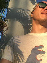 Load image into Gallery viewer, Nate DeWaele, is modeling the t-shirt he designed.  The t-shirt has anaglyph glitch dinosaurs holding flowers. The graphic is in halftone texture for natural blending into the fabric.