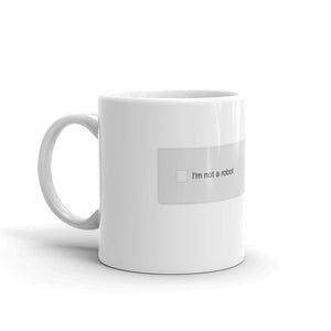 A mug with recaptcha UI that has an empty checkbox indicating the drinker is still a robot- photographed and designed by Nate DeWaele - 11oz handle on left view product
