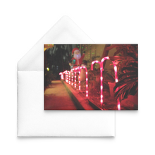 Load image into Gallery viewer, Happy holidays from florida-greeting card front and white envelope-candy canes and monstera with blurry santa claus by nate dewaele at barneydew 